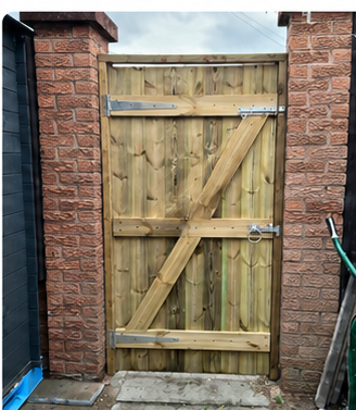 Natural timber ledge-and-brace gate fitted between brick pillars